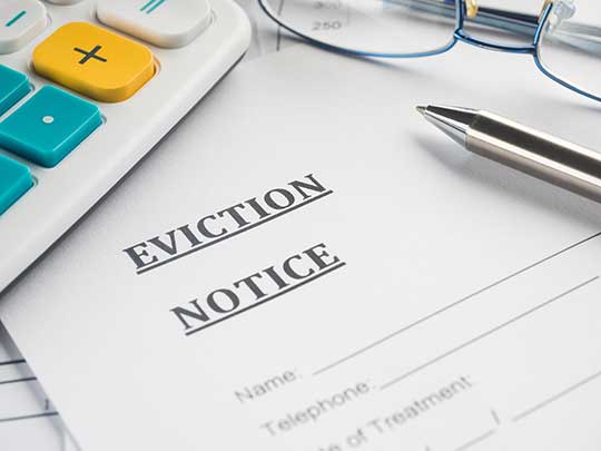 eviction notice, glasses and a calculator