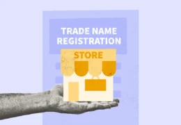 Person holding a model of a store to represent the process of completing trade name registration documents