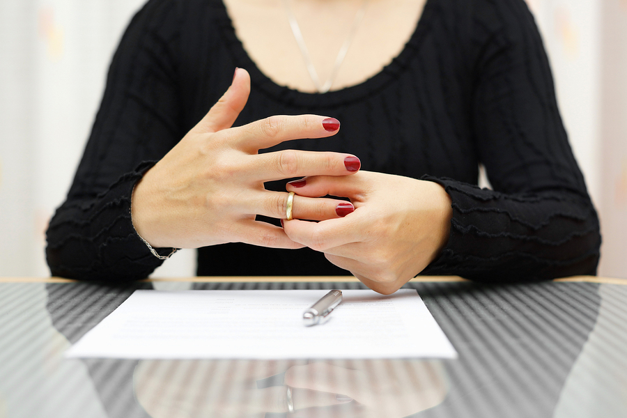 A woman considering divorce stares at a Divorce Agreement
