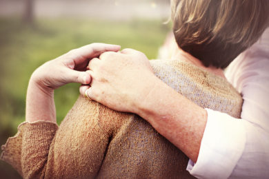 A husband comforts his wife with a hug