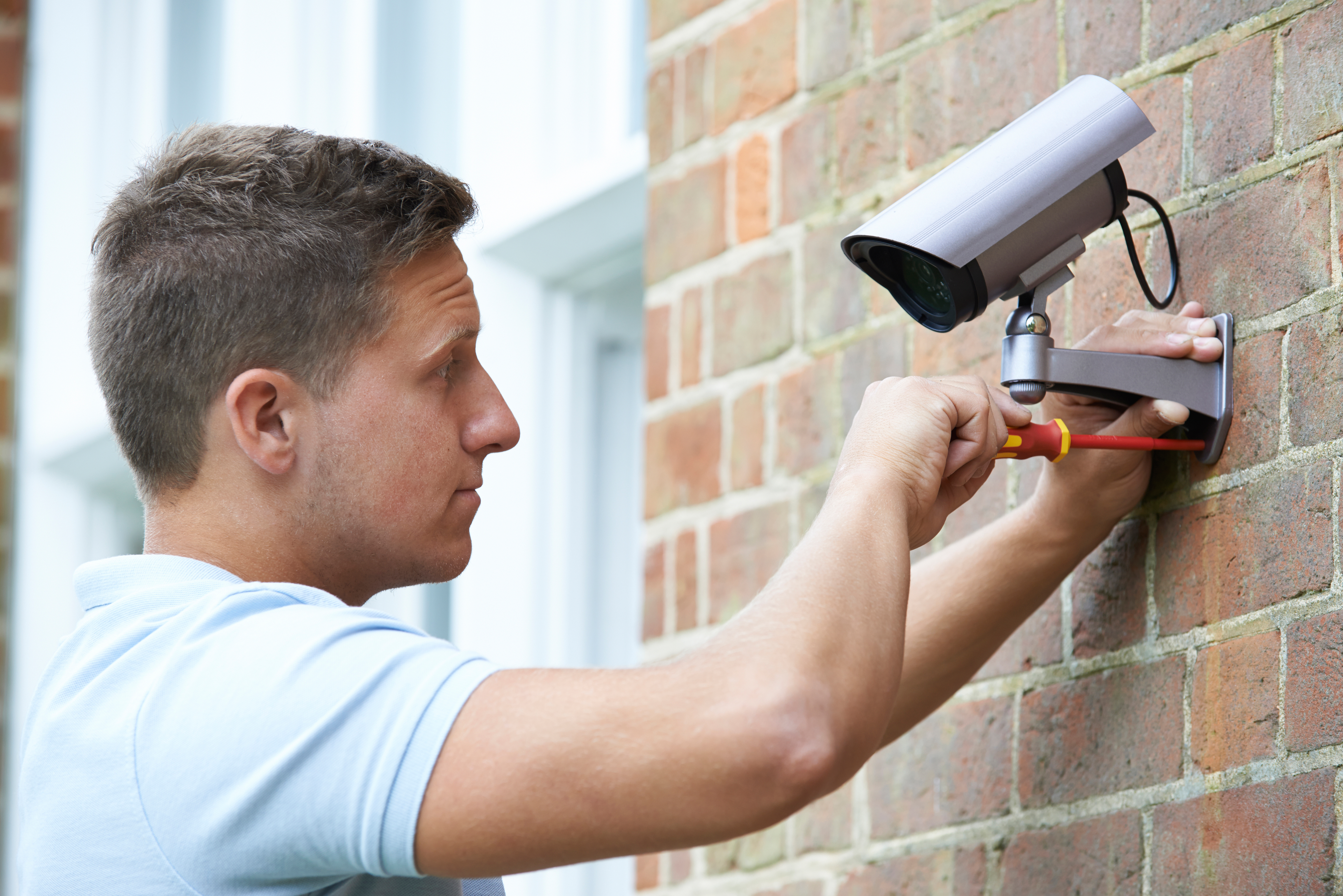 landlord-adding-security-camera-to-property-to-prevent-theft-or-robbery