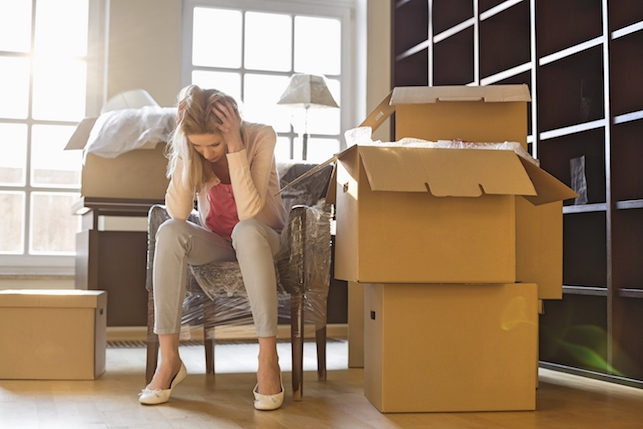Stressed out tenant holds her head in her hands