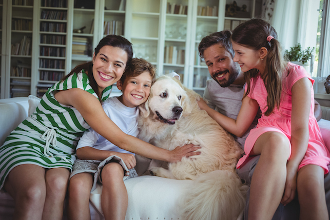 Family hugging pet dog