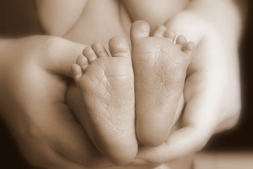 mother holding baby's feet