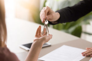 landlord handing apartment keys to new tenant