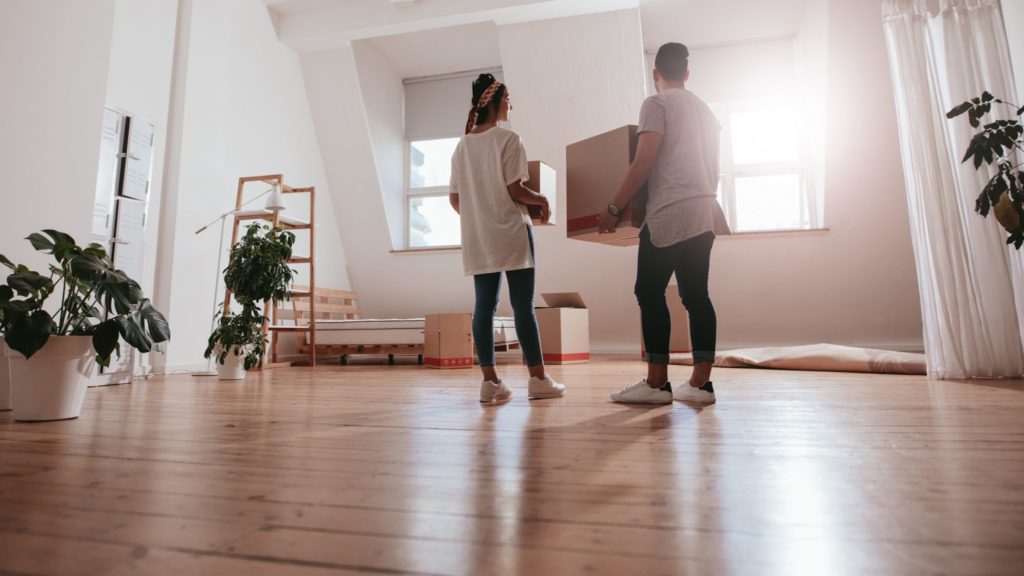 couple moved into new home holding boxes and unpacking