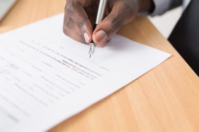 man signing as power of attorney on a document