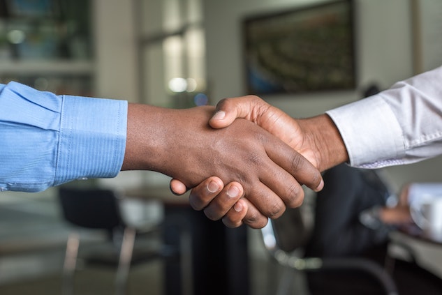 two people shaking hands after making a business deal and signing an nda