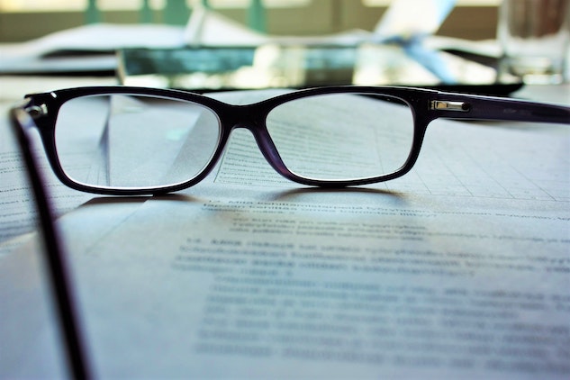 a pair of glasses being laid on an affidavit after learning what it is