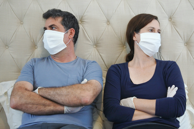 Upset couple in covid-19 quarantine wearing face mask and protective gloves while discussing a divorce