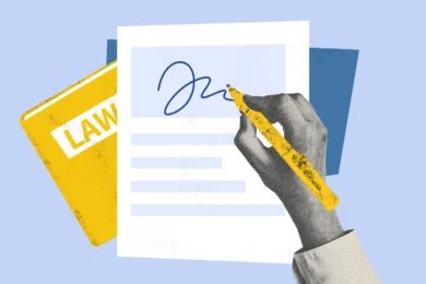 Hand signing a document with a yellow pen, with a law book and papers in the background.