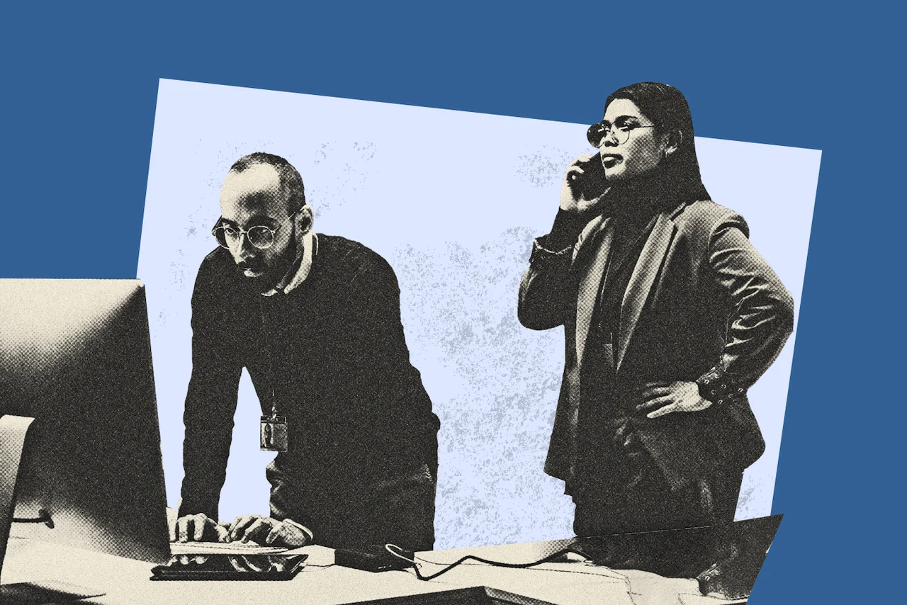 Two professionals working together in an office: one man typing on a computer and one woman speaking on the phone.