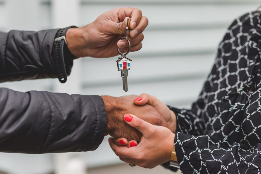 couple exchanging keys to real estate property during divorce