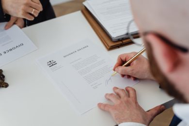 man signing a divorce agreement form